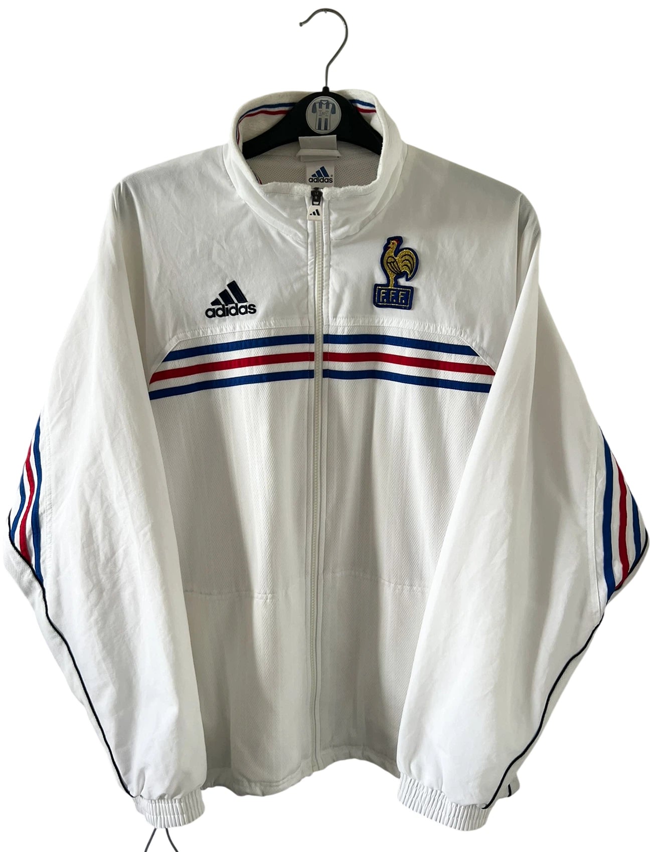 Veste de foot vintage blanche de l'Equipe de France 1998. On peut retrouver l'équipementier Adidas. Il s'agit d'un maillot authentique d'époque.