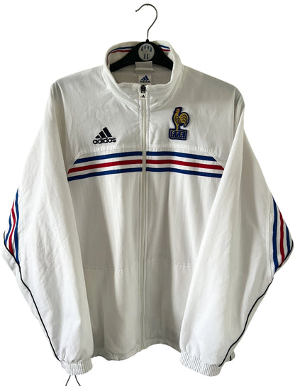 Veste de foot vintage blanche de l'Equipe de France 1998. On peut retrouver l'équipementier Adidas. Il s'agit d'un maillot authentique d'époque.
