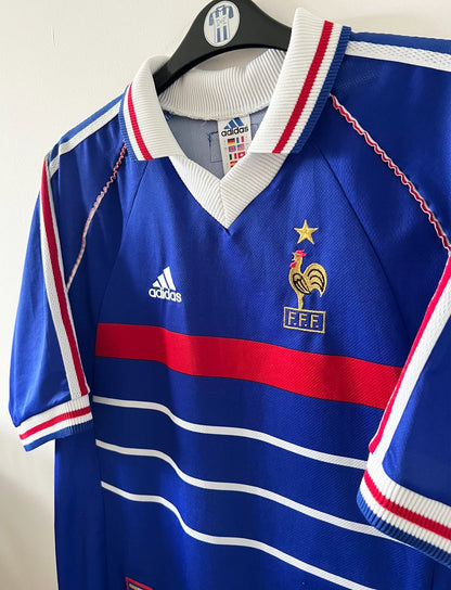 Maillot foot vintage domicile equipe de france 1998 bleu blanc et rouge. On peut retrouver l'équipementier adidas. Ils 'agit d'un maillot authentique d'époque floqué Zinedine Zidane