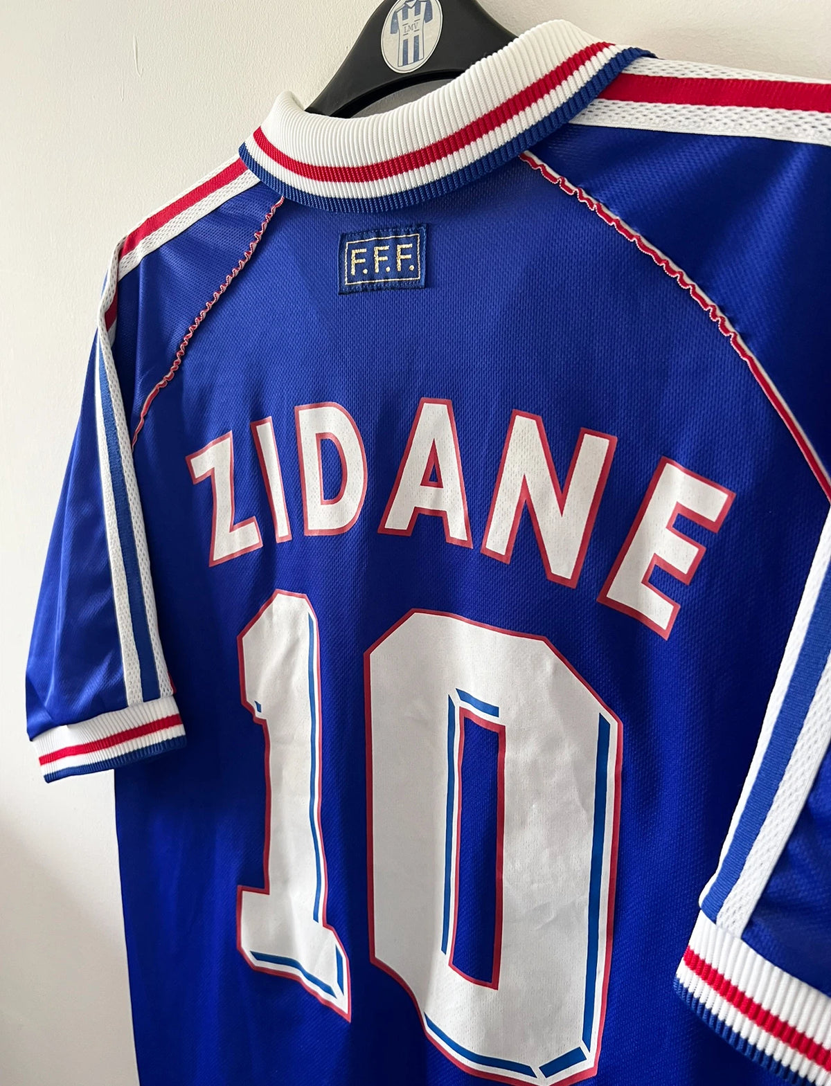 Maillot foot vintage domicile equipe de france 1998 bleu blanc et rouge. On peut retrouver l'équipementier adidas. Le maillot est floqué du numéro 10 Zinedine Zidane. Il s'agit d'un maillot authentique d'époque vendu avec son short d'époque.