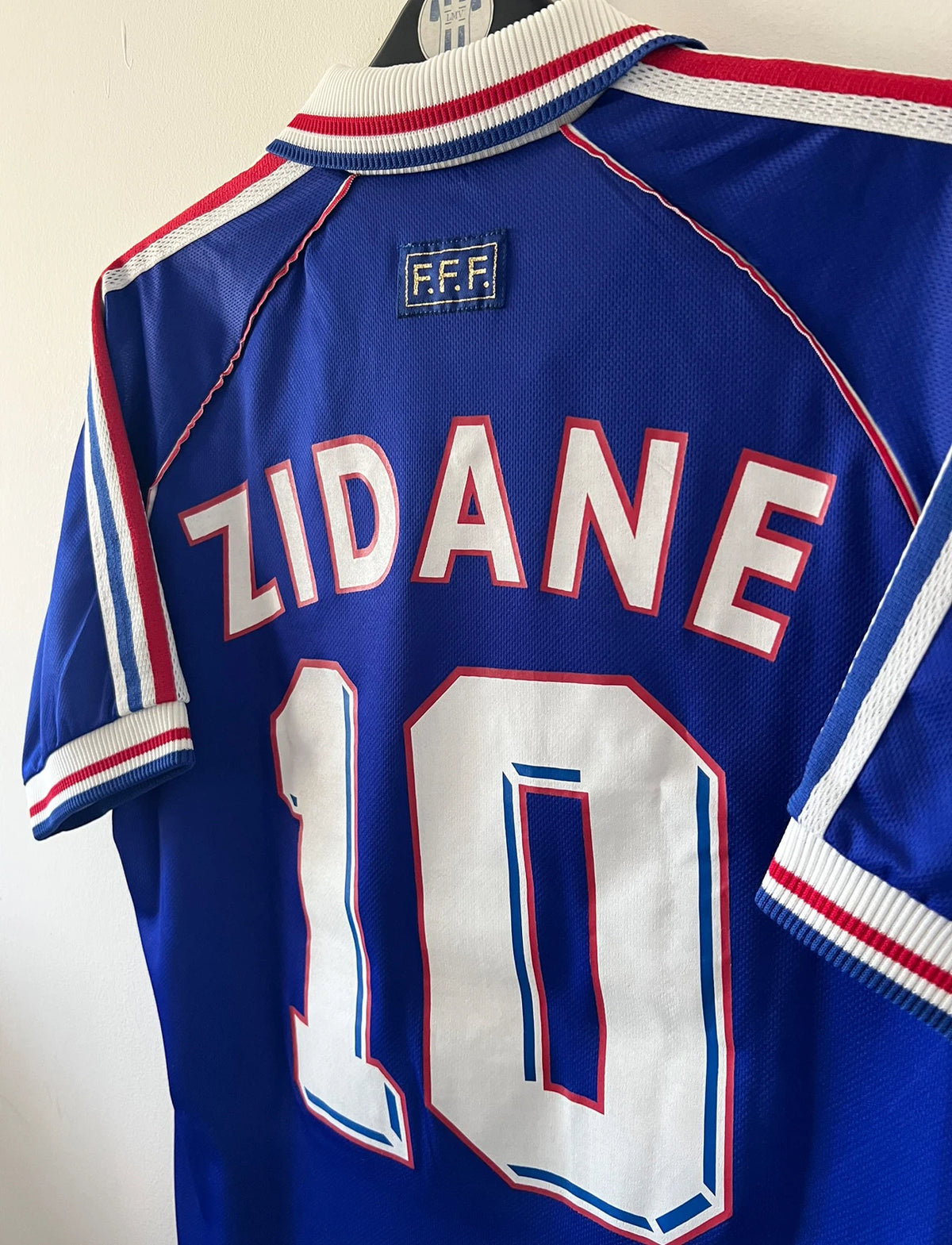 Maillot foot vintage domicile equipe de france 1998 bleu blanc et rouge. On peut retrouver l'équipementier adidas. Le maillot est floqué du numéro 10 Zinedine Zidane. Il s'agit d'un maillot authentique d'époque avec la signature de Zidane en sérigraphié.