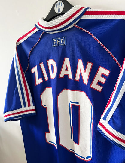 Maillot foot vintage domicile equipe de france 1998 bleu blanc et rouge. On peut retrouver l'équipementier adidas. Ils 'agit d'un maillot authentique d'époque floqué Zinedine Zidane