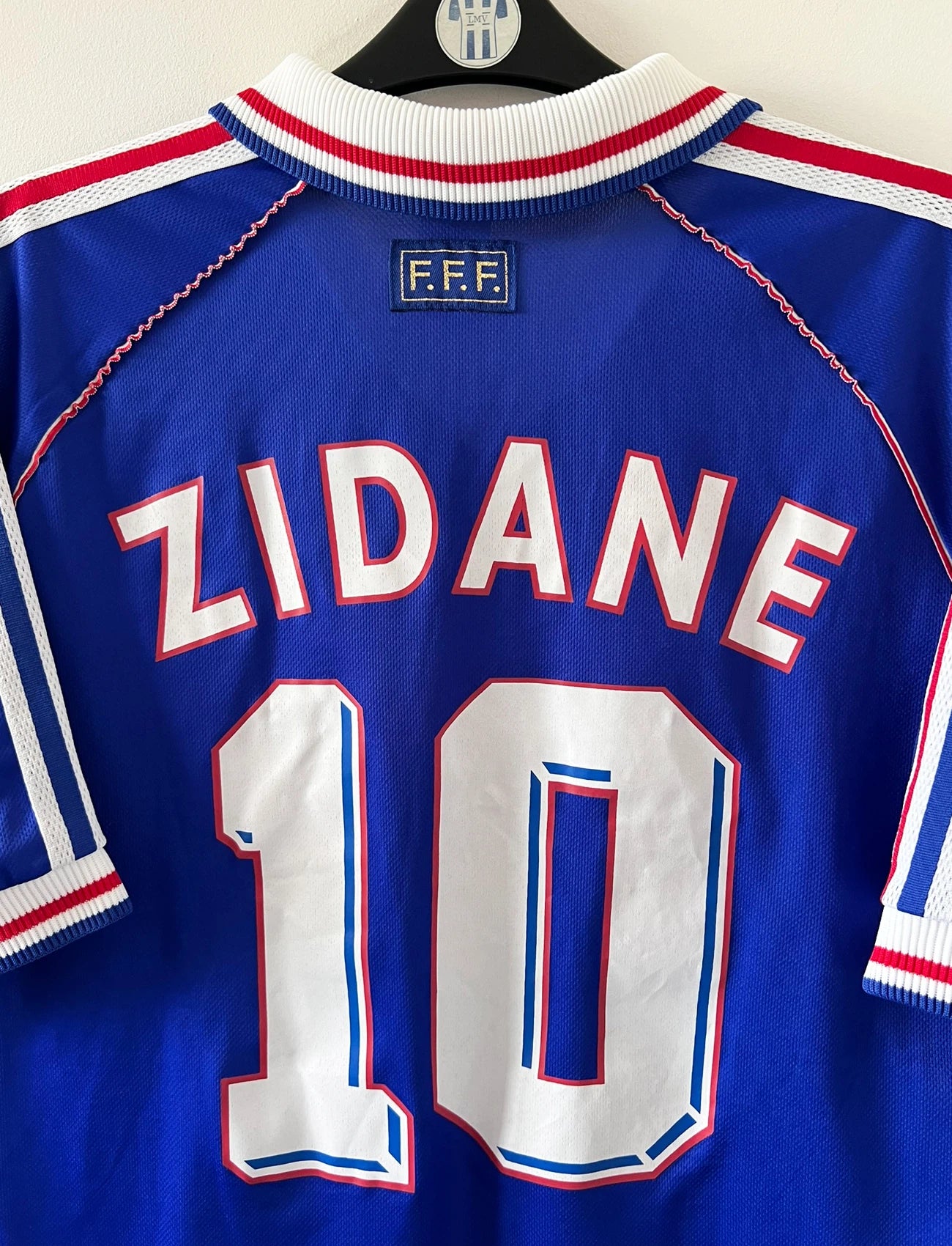 Maillot foot vintage domicile equipe de france 1998 bleu blanc et rouge. On peut retrouver l'équipementier adidas. Le maillot est floqué du numéro 10 Zinedine Zidane. Il s'agit d'un maillot authentique d'époque vendu avec son short d'époque.