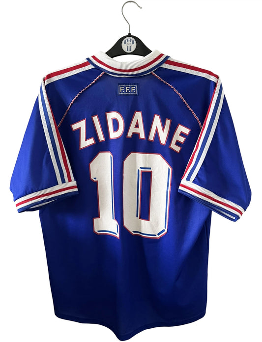 Maillot foot vintage domicile equipe de france 1998 bleu blanc et rouge. On peut retrouver l'équipementier adidas. Ils 'agit d'un maillot authentique d'époque floqué Zinedine Zidane