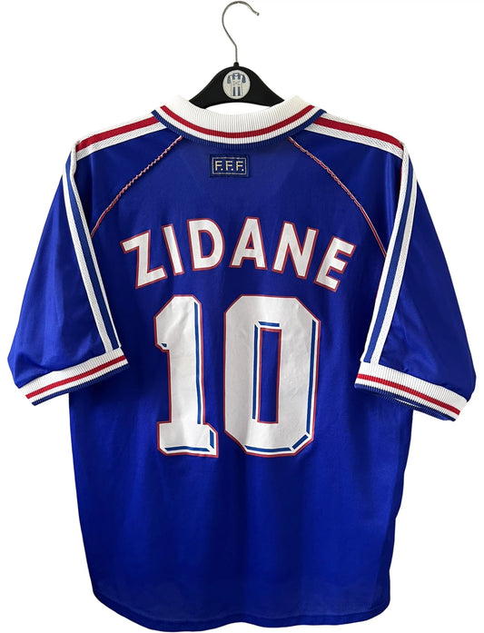 Maillot foot vintage domicile equipe de france 1998 bleu blanc et rouge. On peut retrouver l'équipementier adidas. Le maillot est floqué du numéro 10 Zinedine Zidane. Il s'agit d'un maillot authentique d'époque vendu avec son short d'époque.