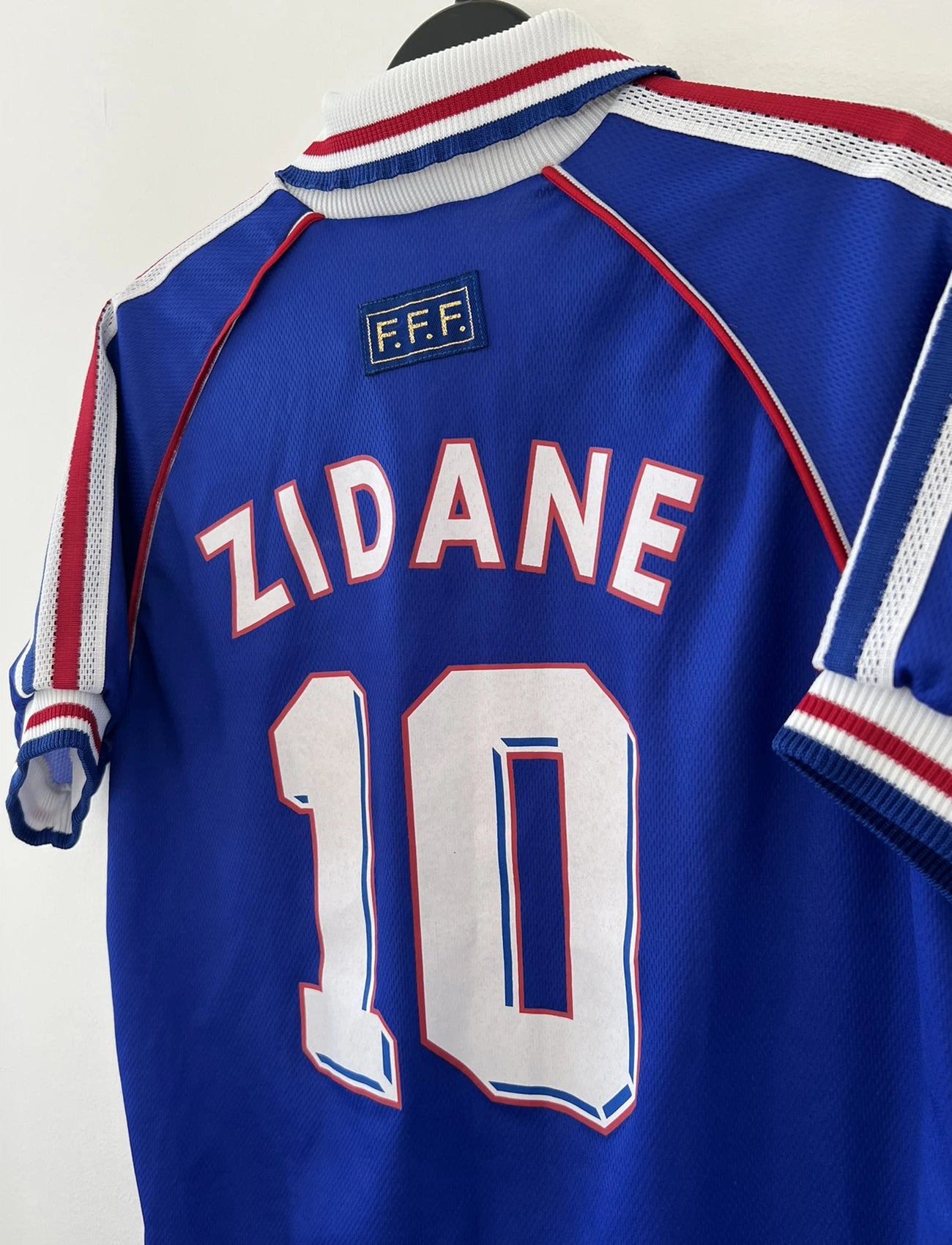Maillot de foot vintage domicile de l'équipe de france 1998 bleu. On peut retrouver l'équipementier adidas. Le maillot est floqué du numéro 10 Zinedine Zidane. Il s'agit d'un maillot authentique d'époque.