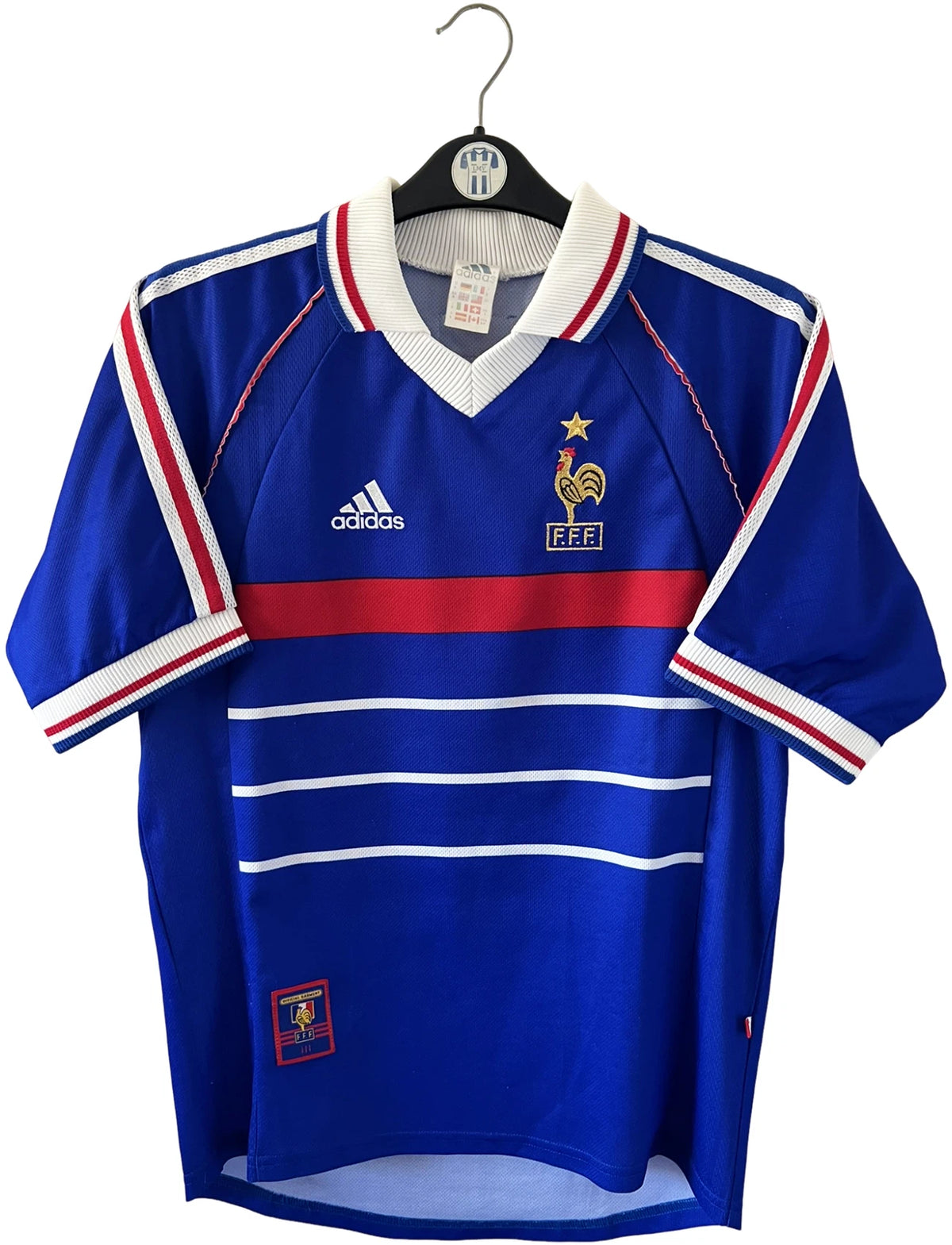 Maillot foot vintage domicile equipe de france 1998 bleu blanc et rouge. On peut retrouver l'équipementier adidas. Le maillot est floqué du numéro 10 Zinedine Zidane. Il s'agit d'un maillot authentique d'époque avec la signature de Zidane en sérigraphié.
