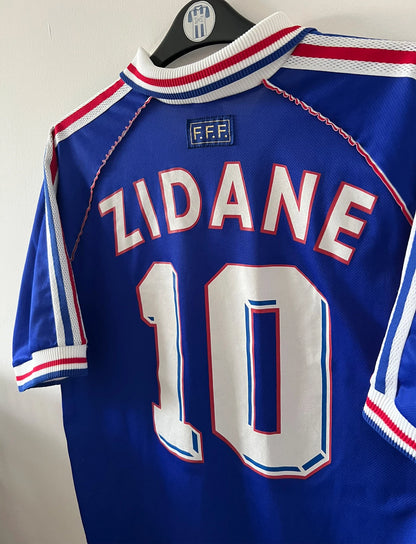 Maillot foot vintage domicile equipe de france 1998 bleu blanc et rouge. On peut retrouver l'équipementier adidas. Ils 'agit d'un maillot authentique d'époque floqué Zinedine Zidane