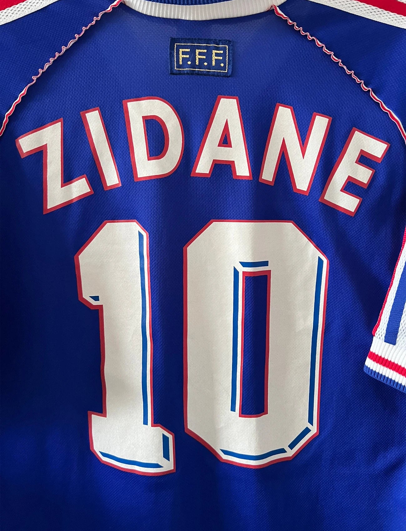 Maillot foot vintage domicile equipe de france 1998 bleu blanc et rouge. On peut retrouver l'équipementier adidas. Ils 'agit d'un maillot authentique d'époque floqué Zinedine Zidane