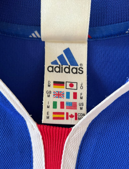 Maillot de foot vintage domicile bleu de l'équipe de france 2000. On peut retrouver l'équipementier Adidas. Le maillot est floqué du numéro 10 Zidane. Il s'agit d'un maillot authentique d'époque.