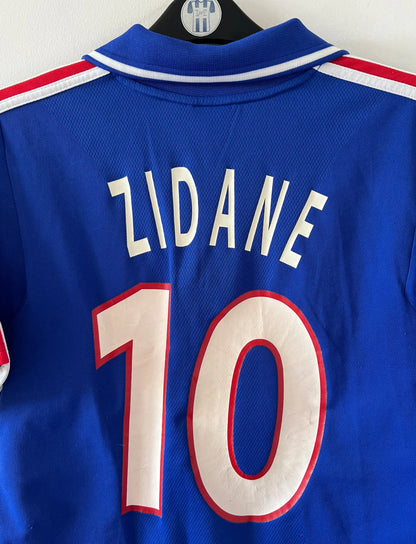 Maillot de foot vintage domicile bleu de l'équipe de france 2000. On peut retrouver l'équipementier Adidas. Le maillot est floqué du numéro 10 Zidane. Il s'agit d'un maillot authentique d'époque.