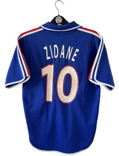 Maillot de foot vintage domicile bleu de l'équipe de france 2000. On peut retrouver l'équipementier Adidas. Le maillot est floqué du numéro 10 Zidane. Il s'agit d'un maillot authentique d'époque.