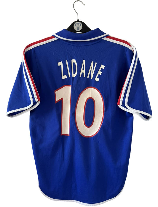 Maillot de foot vintage domicile bleu de l'équipe de france 2000. On peut retrouver l'équipementier Adidas. Le maillot est floqué du numéro 10 Zidane. Il s'agit d'un maillot authentique d'époque.