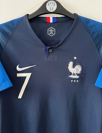 Maillot de foot vintage domicile bleu de l'équipe de france 2018 floqué Griezmann. On peut retrouver l'équipementier Nike. Le maillot est floqué du numéro 7 Antoine Griezmann. Il s'agit d'un maillot authentique d'époque.