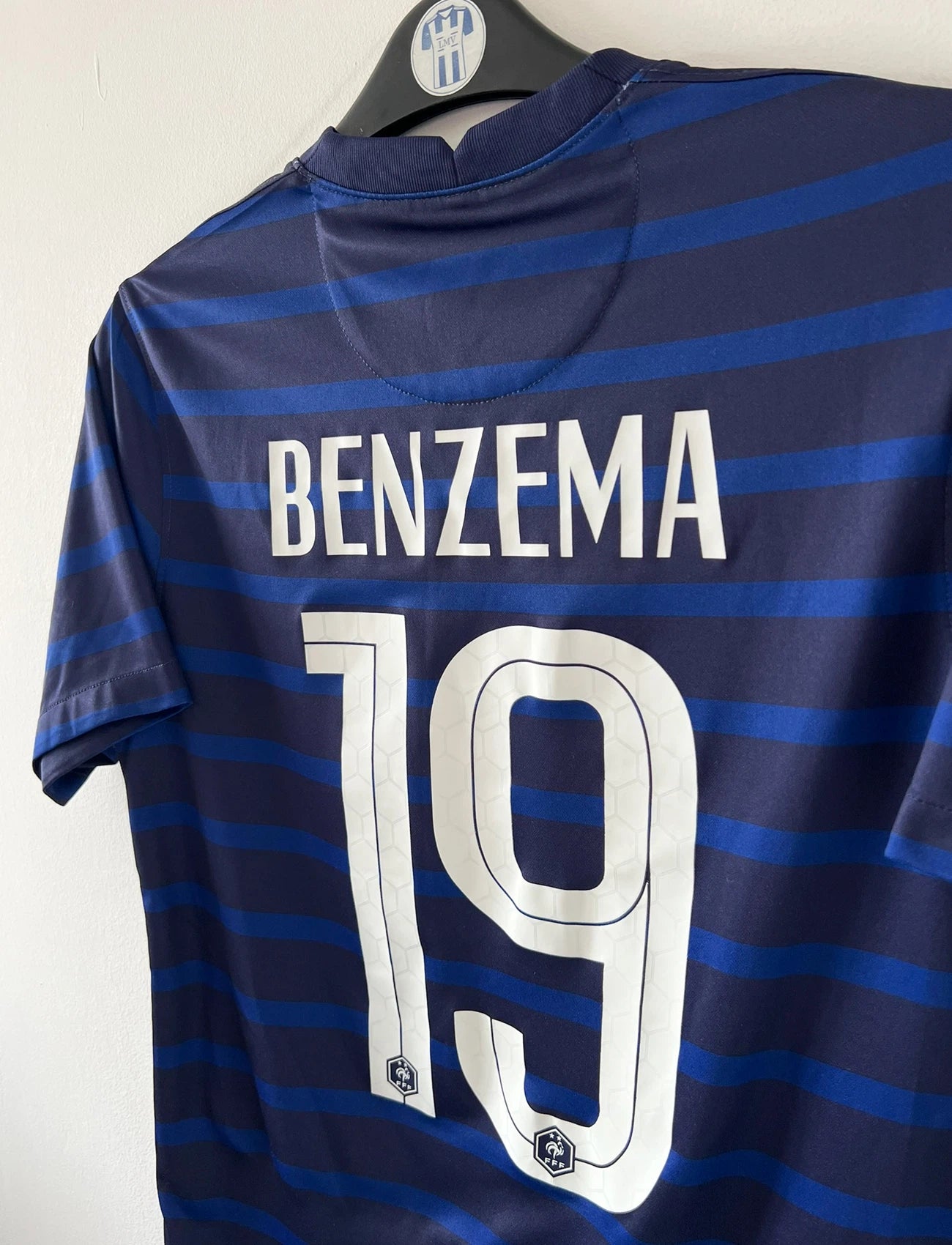 Maillot de foot vintage domicile bleu de l'équipe de france 2020/2021. On peut retrouver l'équipementier Nike. Le maillot est floqué du numéro 19 Karim Benzema. Il s'agit d'un maillot authentique d'époque.