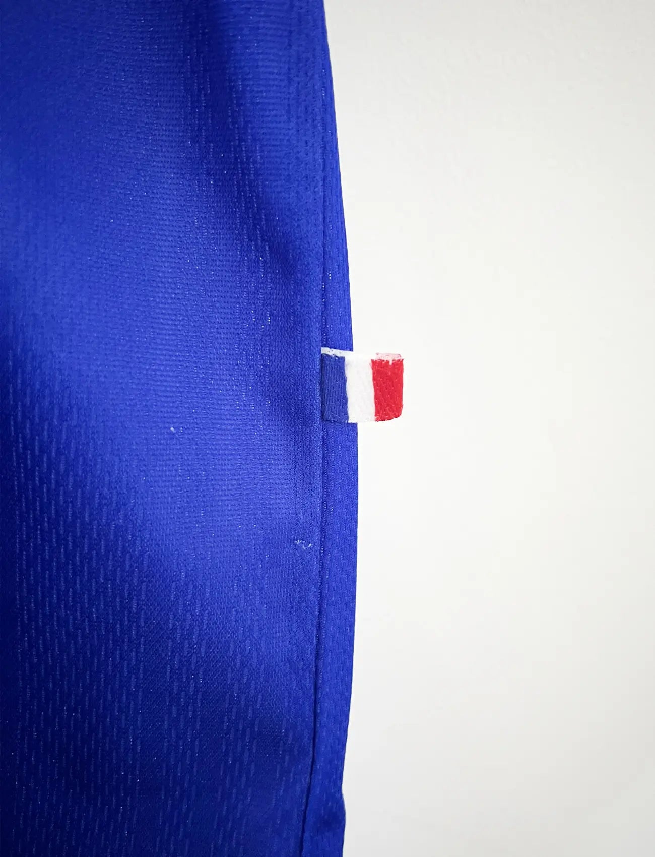 Maillot de foot vintage bleu, blanc et rouge de l'équipe de france 1998. On peut retrouver l'équipementier adidas. Il s'agit d'un maillot authentique édité avant la finale de la coupe du monde car celui-ci ne possède pas l'étoile.