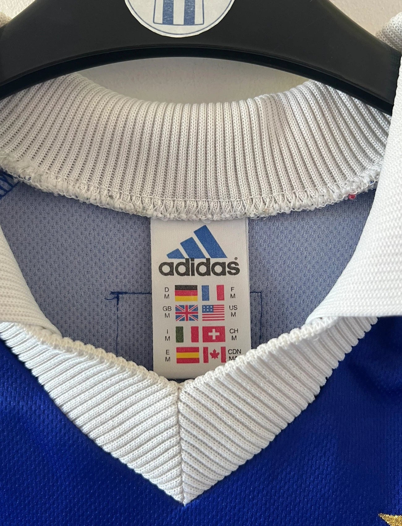 Maillot de foot vintage domicile bleu de l'équipe de france 1998. On peut retrouver l'équipementier Adidas. Le maillot est floqué du numéro 10 Zinedine Zidane. Il s'agit d'un maillot authentique d'époque.