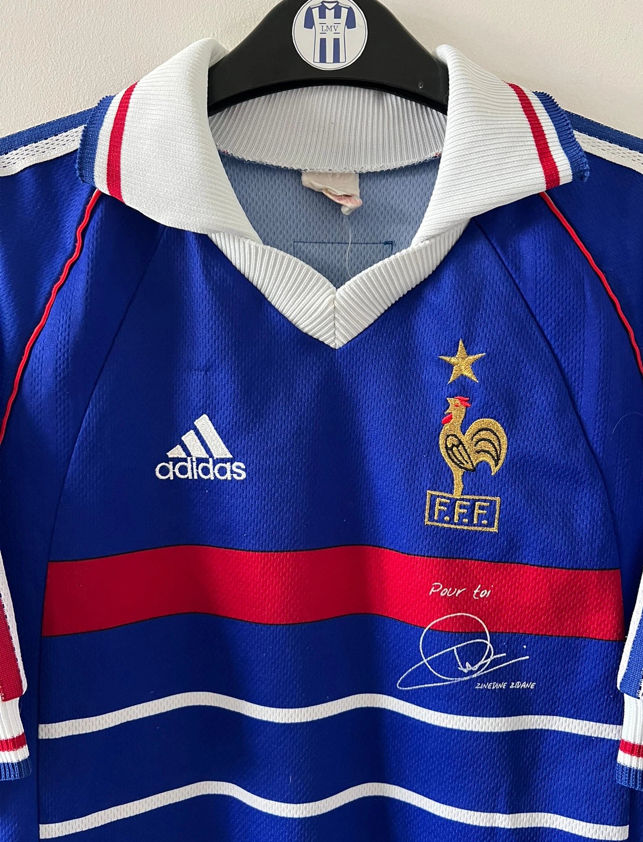 Maillot de foot vintage domicile bleu de l'équipe de france 1998. On peut retrouver l'équipementier Adidas. Le maillot est floqué du numéro 10 Zinedine Zidane. Il s'agit d'un maillot authentique d'époque.