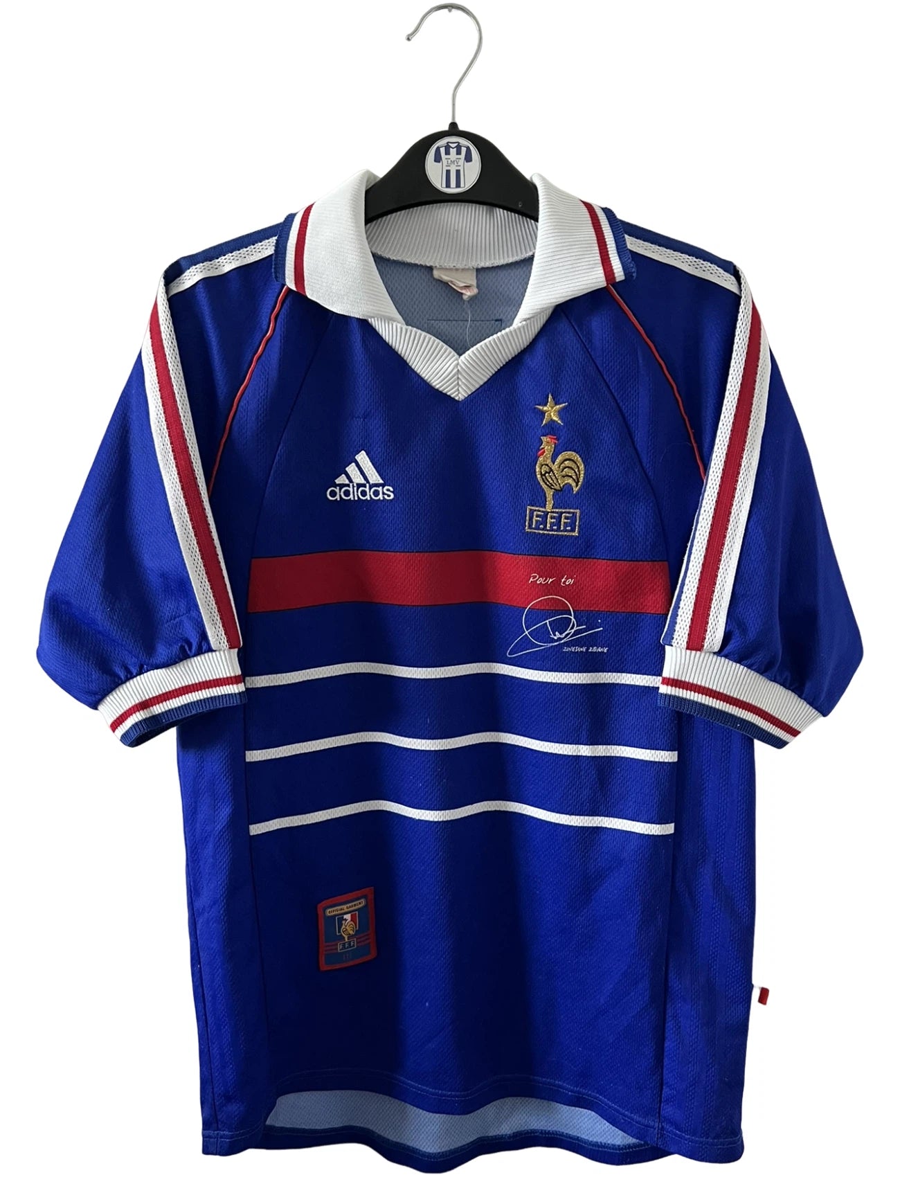 Maillot de foot vintage domicile bleu de l'équipe de france 1998. On peut retrouver l'équipementier Adidas. Le maillot est floqué du numéro 10 Zinedine Zidane. Il s'agit d'un maillot authentique d'époque.