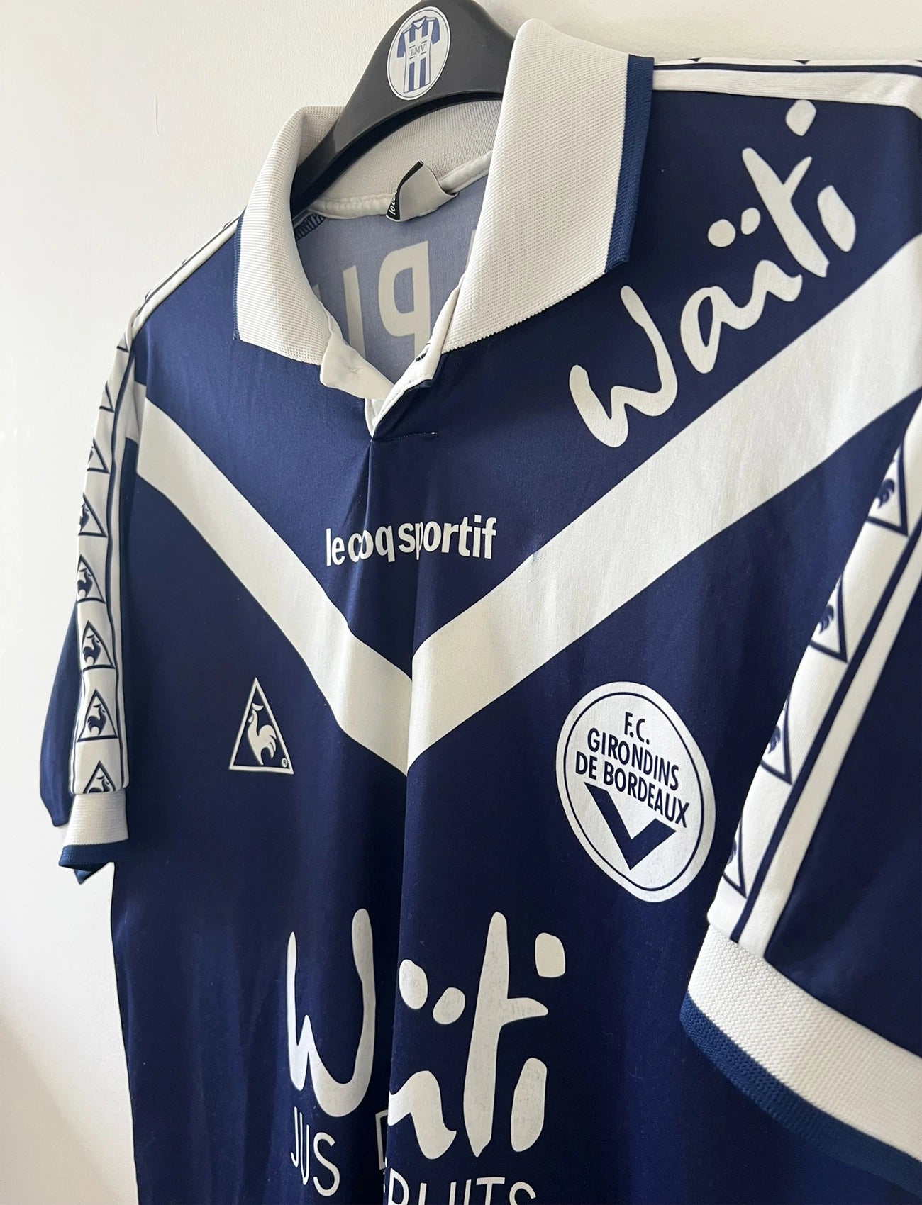 Maillot de foot vintage domicile bleu et blanc des girondins de bordeaux de la saison 1996/1997. On peut retrouver l'équipementier Le Coq Sportif et le sponsor Waïti. Le maillot est floqué du numéro 27 Papin. Il s'agit d'un maillot authentique d'époque.
