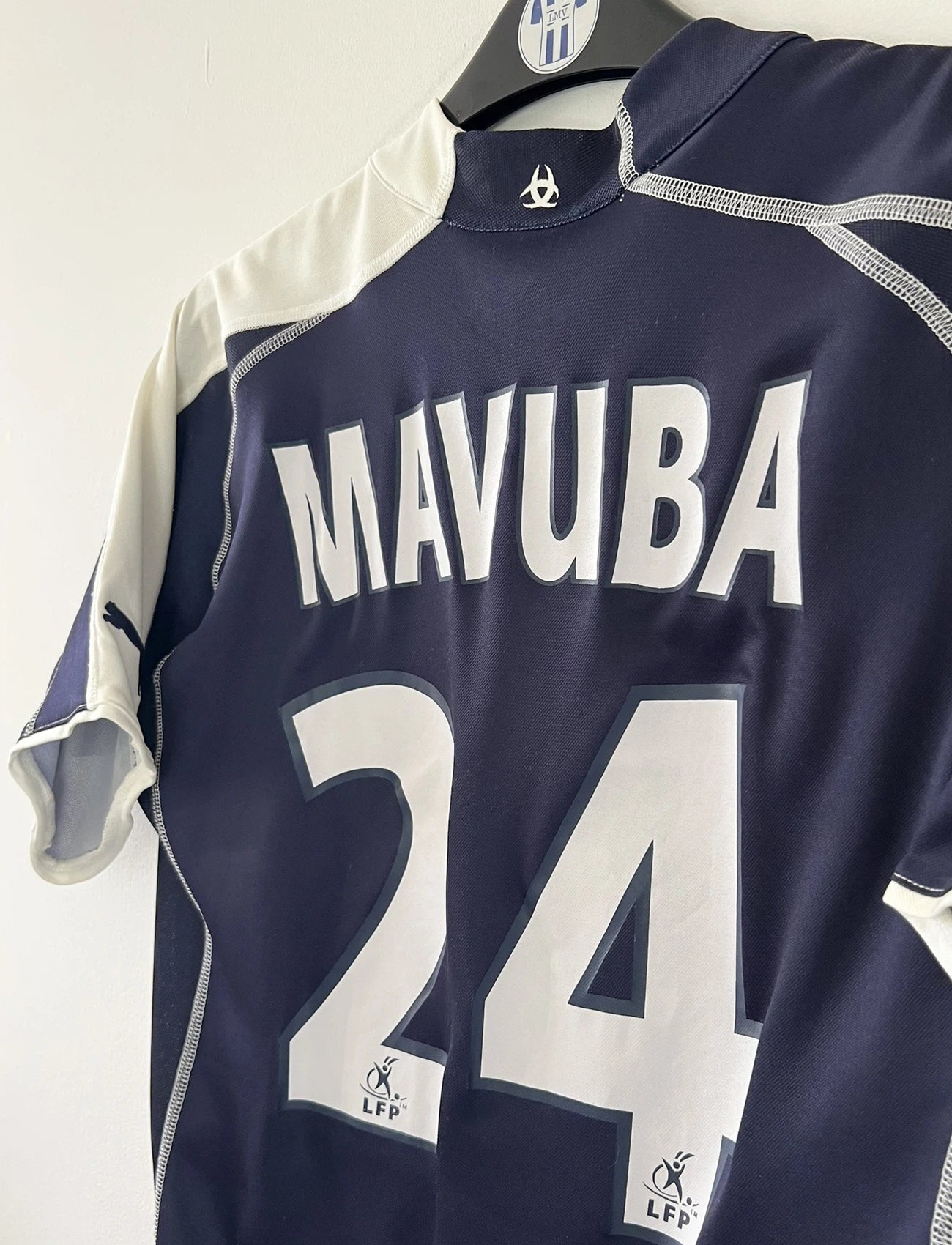 Maillot de foot vintage domicile bleu des Girondins de Bordeaux de la saison 2004-2005. On peut retrouver l'équipementier Puma et le sponsor Motorola. Le maillot est floqué du numéro 24 Mavuba. Il s'agit d'un maillot authentique d'époque.