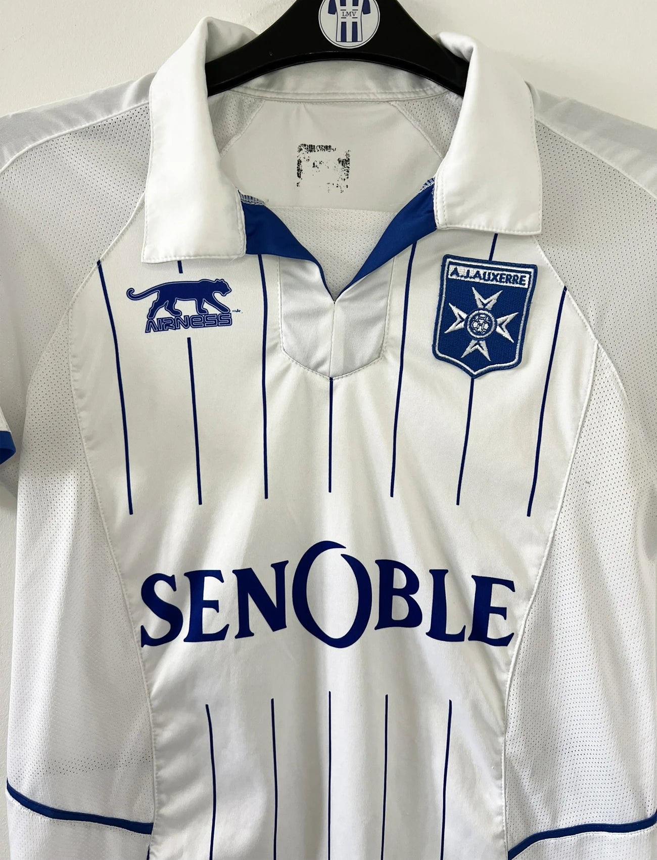 Maillot de foot vintage domicile blanc de l'AJ Auxerre de la saison 2010-2011. On peut retrouver l'équipementier airness et le sponsor senoble. Il s'agit d'un maillot authentique d'éppoque.