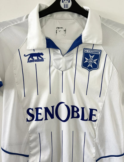 Maillot de foot vintage domicile blanc de l'AJ Auxerre de la saison 2010-2011. On peut retrouver l'équipementier airness et le sponsor senoble. Il s'agit d'un maillot authentique d'éppoque.