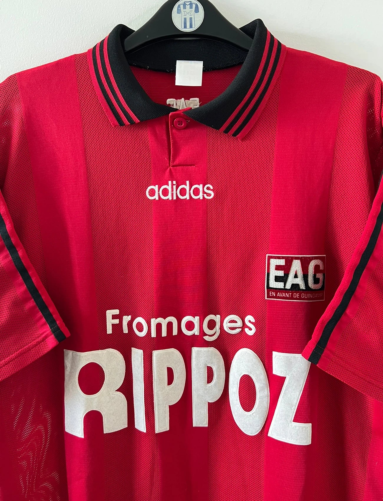 Maillot de foot vintage domicile rouge de Guingamp 1996/1997. On peut retrouver l'équipementier Adidas et le sponsor Fromages Rippoz. Il s'agit d'un maillot authentique d'époque.