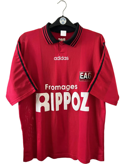 Maillot de foot vintage domicile rouge de Guingamp 1996/1997. On peut retrouver l'équipementier Adidas et le sponsor Fromages Rippoz. Il s'agit d'un maillot authentique d'époque.