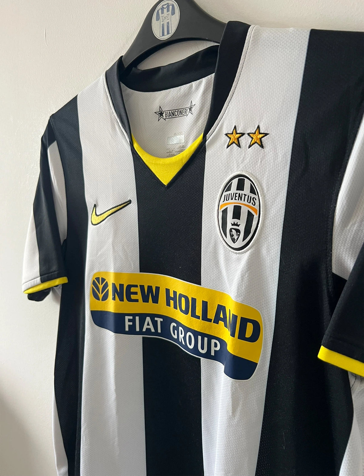 Maillot de foot vintage domicile blanc et noir de la Juventus 2008/2009. On peut retrouver l'équipementier Nike et le sponsor New Holland. Il s'agit d'un maillot authentique d'époque.