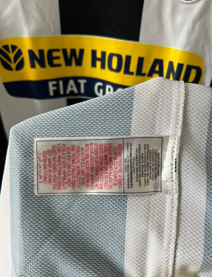 Maillot de foot vintage domicile blanc et noir de la Juventus 2008/2009. On peut retrouver l'équipementier Nike et le sponsor New Holland. Il s'agit d'un maillot authentique d'époque.