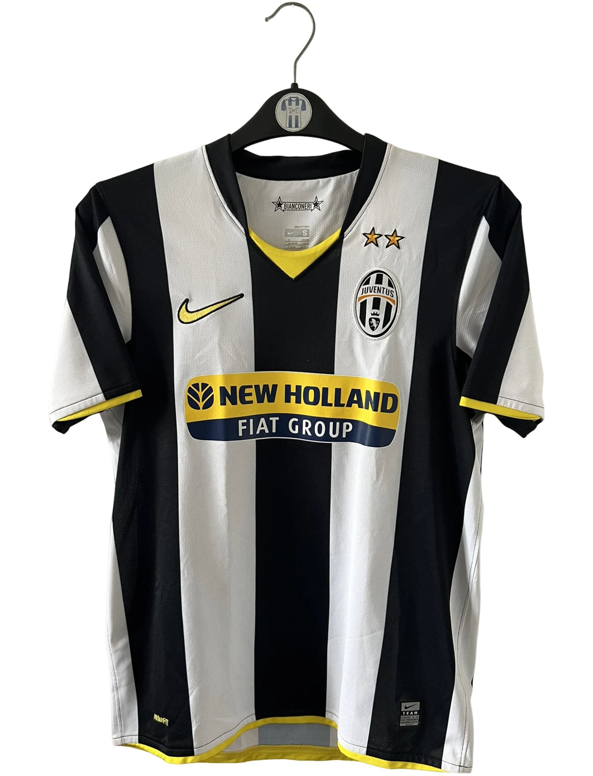 Maillot de foot vintage domicile blanc et noir de la Juventus 2008/2009. On peut retrouver l'équipementier Nike et le sponsor New Holland. Il s'agit d'un maillot authentique d'époque.
