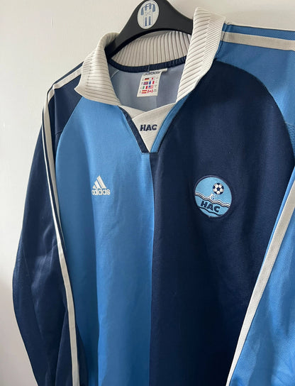 Maillot de foot vintage domicile bleu du Havre de la saison 2000/2002. On peut retrouver l'équipementier Adidas. Il s'agit d'un maillot issu du stock pro, authentique d'époque. 