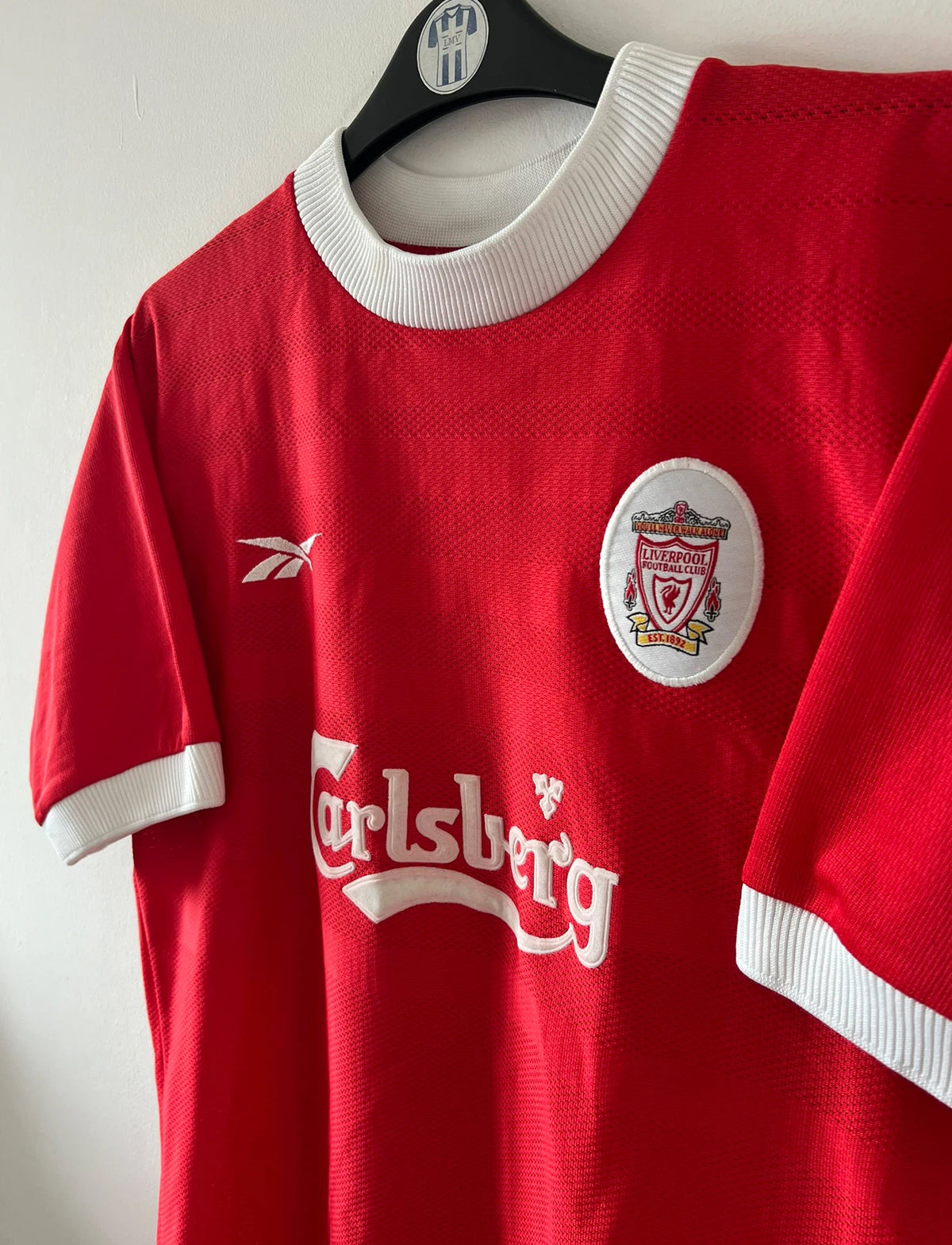 Maillot de foot vintage domicile rouge et blanc de liverpool de la saison 1998/2000. On peut retrouver l'équipementier Reebok et le sponsor Carlsberg. Le maillot est floqué du numéro 10 Michael Owen. Il s'agit d'un maillot authentique d'époque.