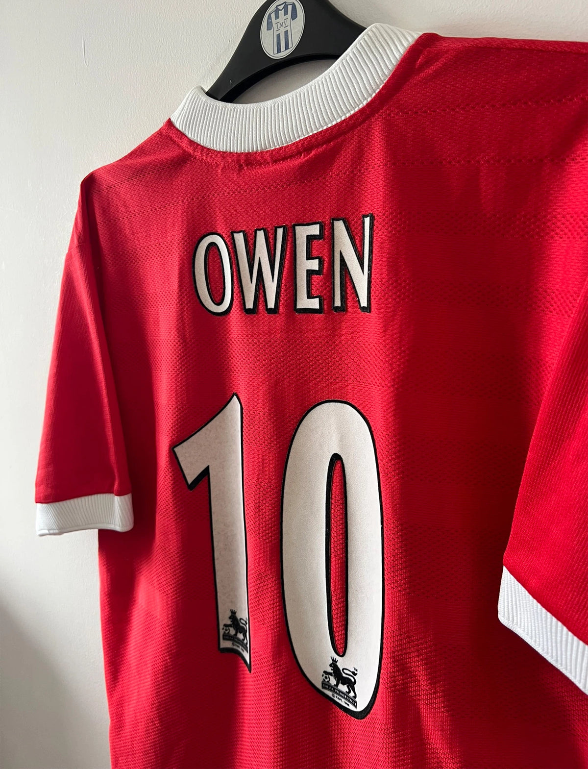 Maillot de foot vintage domicile rouge et blanc de liverpool de la saison 1998/2000. On peut retrouver l'équipementier Reebok et le sponsor Carlsberg. Le maillot est floqué du numéro 10 Michael Owen. Il s'agit d'un maillot authentique d'époque.