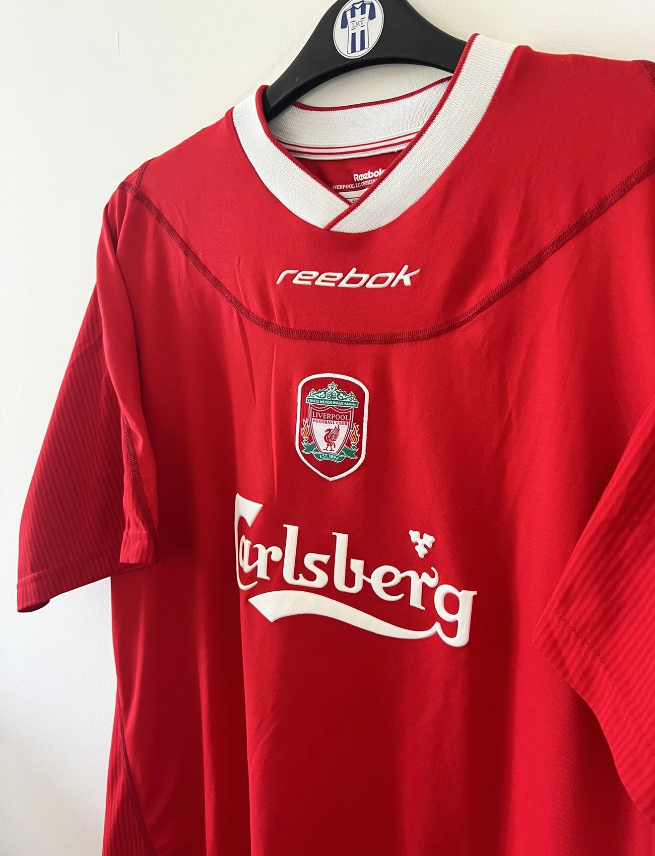Maillot de foot vintage domicile rouge de liverpool de la saison 2002/2004. On peut retrouver l'équipementier Reebok. Il s'agit d'un maillot authentique d'époque