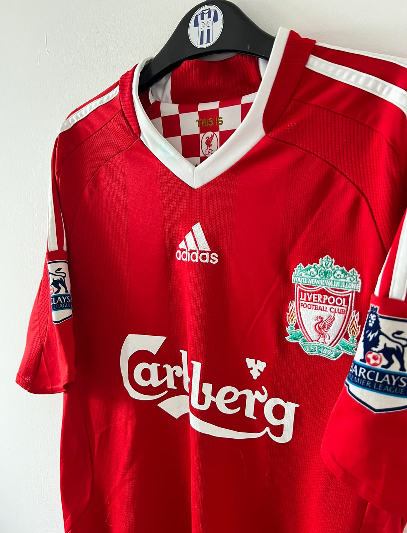 Maillot de foot vintage domicile rouge de Liverpool 2008/2009. On peut retrouver l'équipementier Adidas et le sponsor Carlsberg. Le maillot est floqué du numéro 23 Carragher. Il s'agit d'un maillot authentique d'époque.