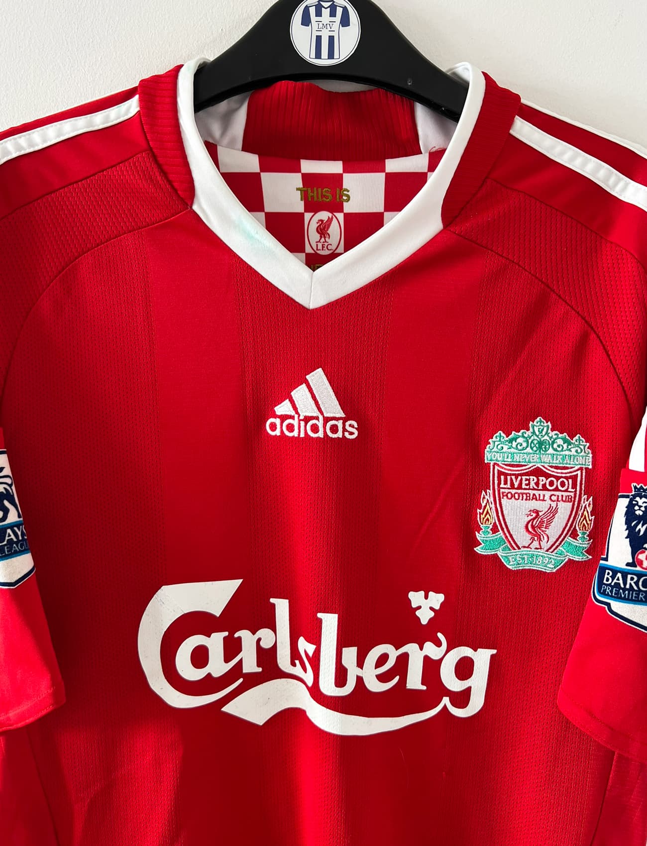 Maillot de foot vintage domicile rouge de Liverpool 2008/2009. On peut retrouver l'équipementier Adidas et le sponsor Carlsberg. Le maillot est floqué du numéro 23 Carragher. Il s'agit d'un maillot authentique d'époque.