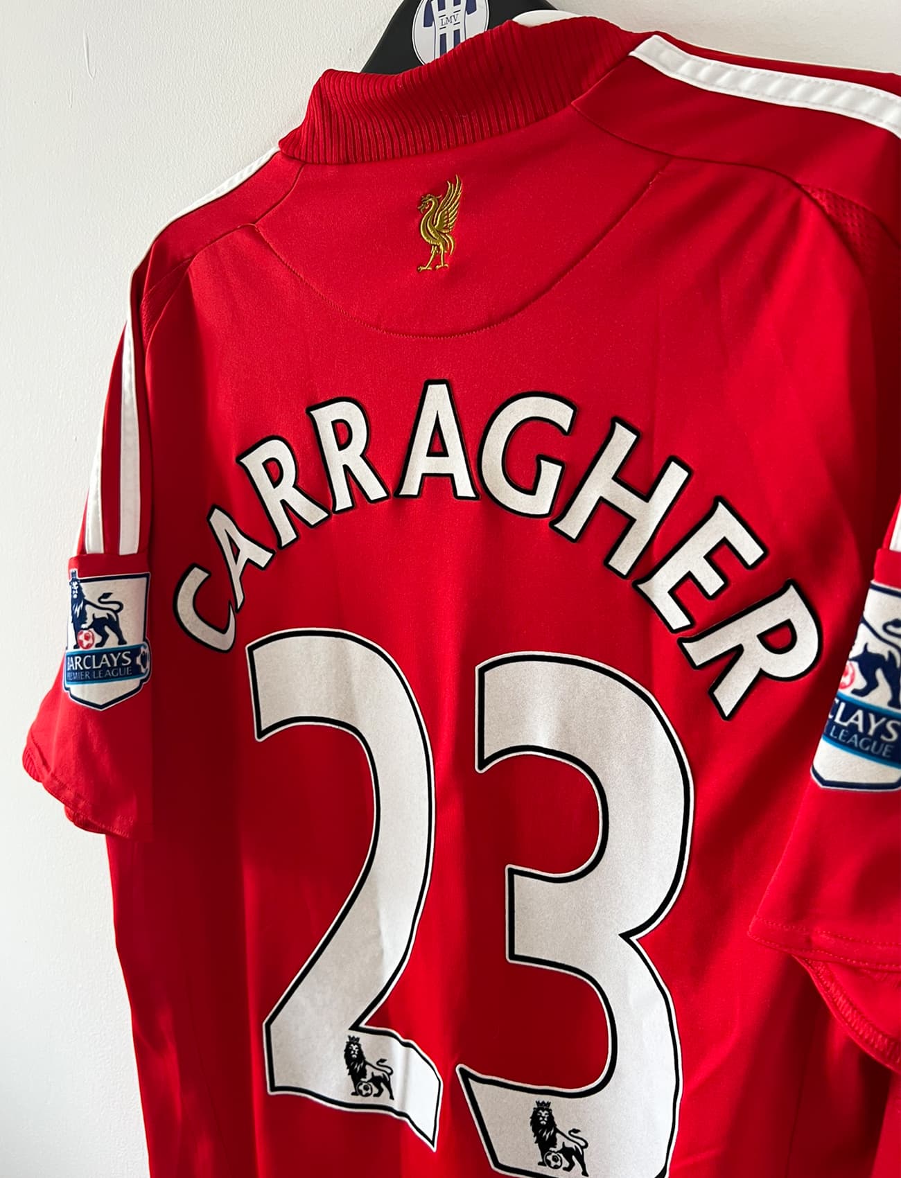 Maillot de foot vintage domicile rouge de Liverpool 2008/2009. On peut retrouver l'équipementier Adidas et le sponsor Carlsberg. Le maillot est floqué du numéro 23 Carragher. Il s'agit d'un maillot authentique d'époque.