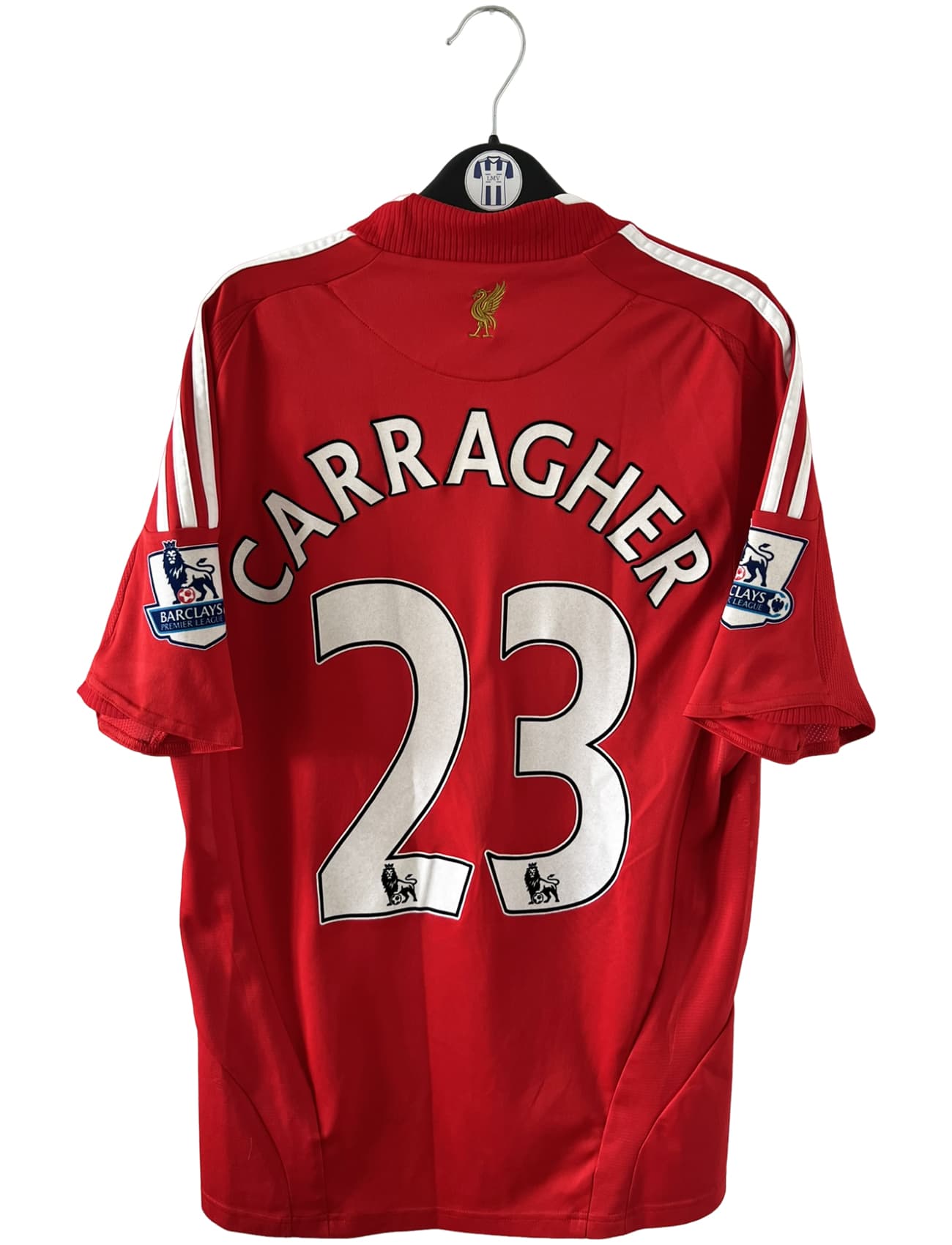 Maillot de foot vintage domicile rouge de Liverpool 2008/2009. On peut retrouver l'équipementier Adidas et le sponsor Carlsberg. Le maillot est floqué du numéro 23 Carragher. Il s'agit d'un maillot authentique d'époque.