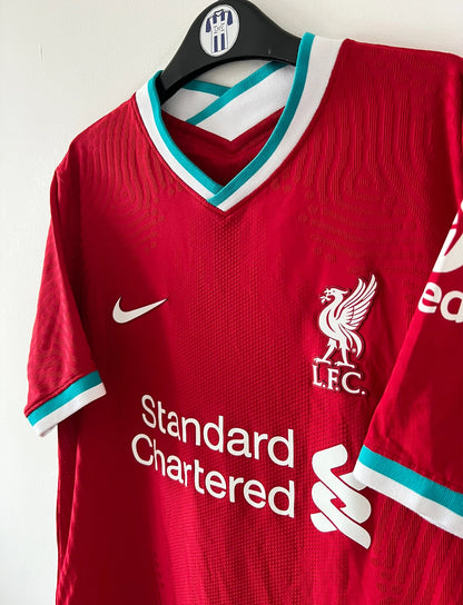 Maillot de foot vintage domicile rouge de Liverpool 2020/2021 en version vapor. On peut retrouver l'équipementier Nike et le sponsor Standard Chartered. Il s'agit d'un maillot authentique d'époque.
