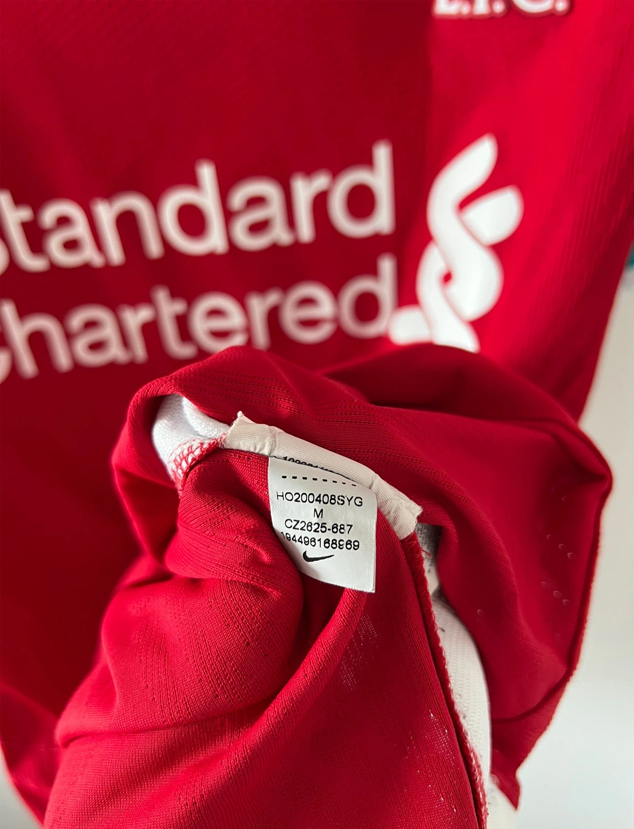 Maillot de foot vintage domicile rouge de Liverpool 2020/2021 en version vapor. On peut retrouver l'équipementier Nike et le sponsor Standard Chartered. Il s'agit d'un maillot authentique d'époque.