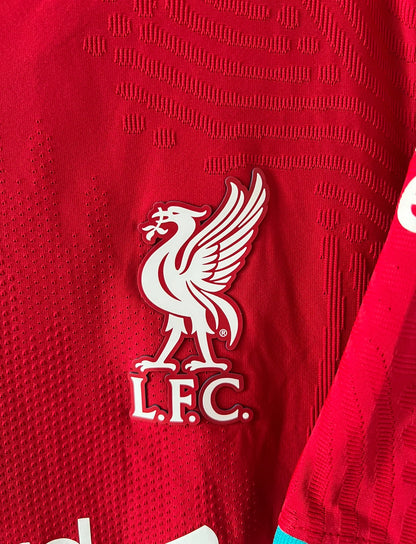Maillot de foot vintage domicile rouge de Liverpool 2020/2021 en version vapor. On peut retrouver l'équipementier Nike et le sponsor Standard Chartered. Il s'agit d'un maillot authentique d'époque.