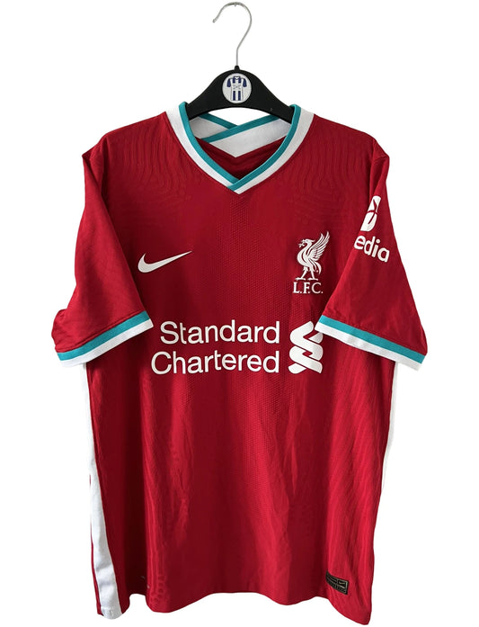 Maillot de foot vintage domicile rouge de Liverpool 2020/2021 en version vapor. On peut retrouver l'équipementier Nike et le sponsor Standard Chartered. Il s'agit d'un maillot authentique d'époque.