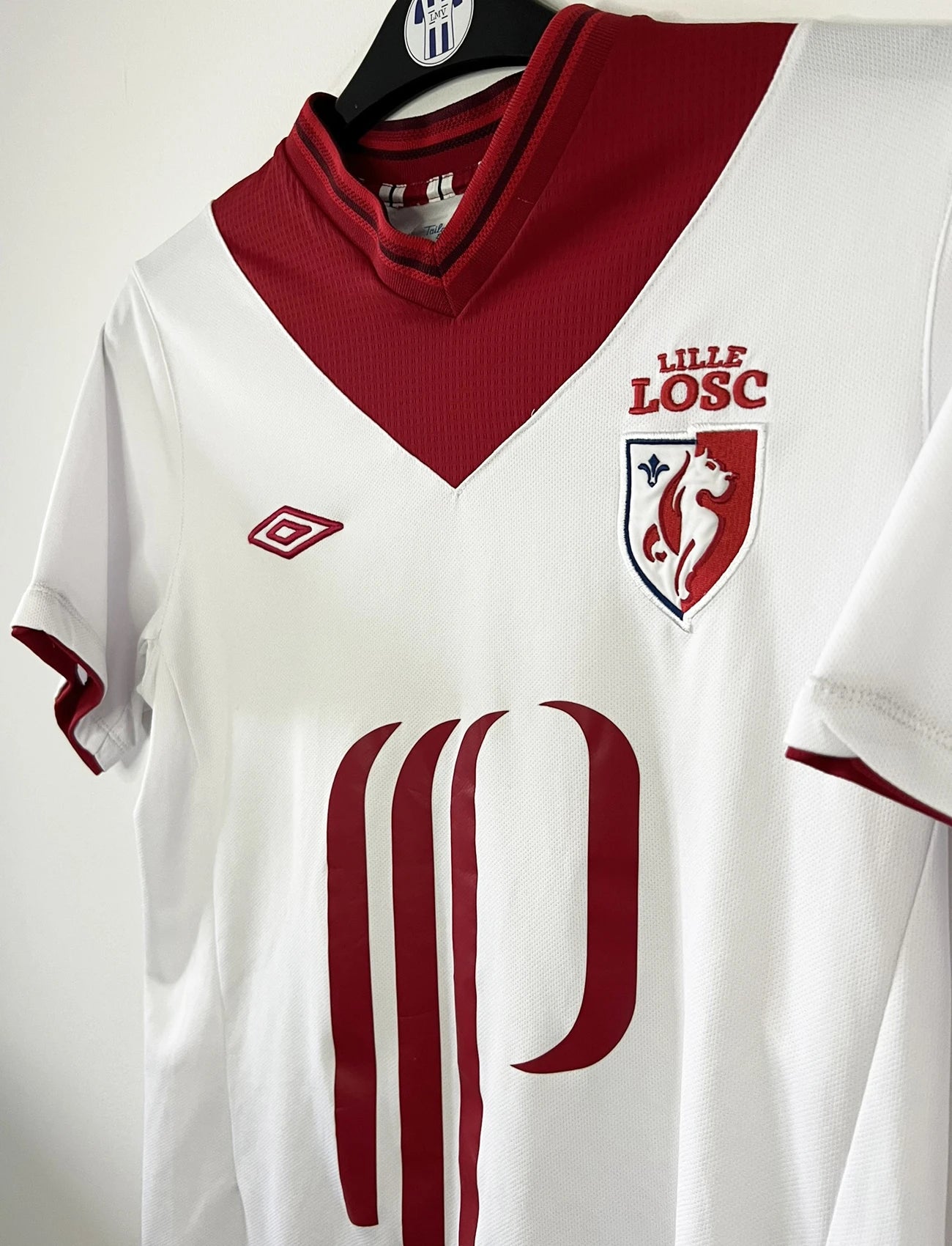 Maillot extérieur du LOSC lors de la saison 2012 2013. On retrouve l'équipementier umbro. Le maillot est de couleur blanc et rouge