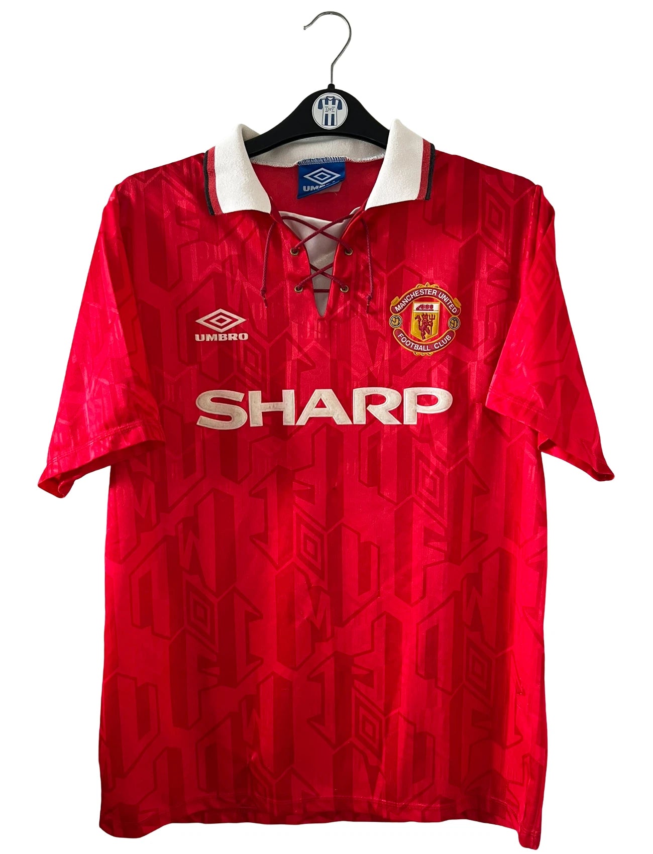 Maillot de foot vintage domicile rouge de Manchester United de la saison 1992/1994. On peut retrouver l'équipementier Umbro et le sponsor Sharp. Il s'agit d'un maillot authentique d'époque.