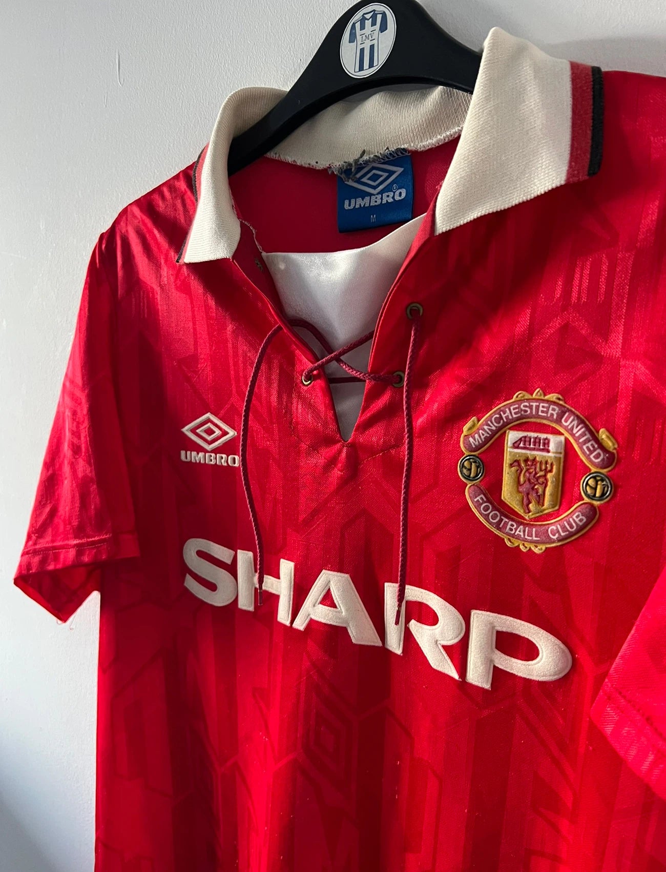 Maillot de foot vintage domicile rouge de manchester united 1992/1994. On peut retrouver l'équipementier umbro et le sponsor Sharp. Il s'agit d'un maillot authentique d'époque.