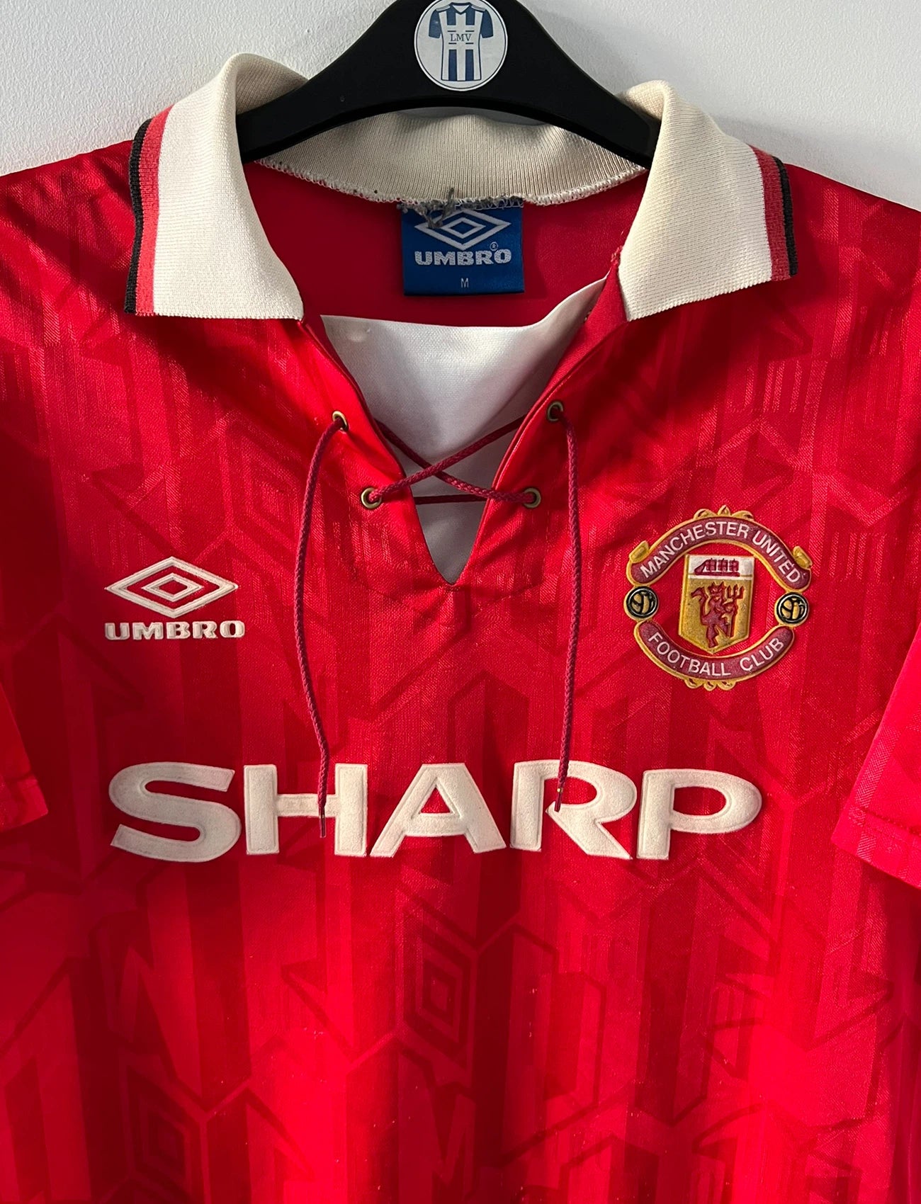 Maillot de foot vintage domicile rouge de manchester united 1992/1994. On peut retrouver l'équipementier umbro et le sponsor Sharp. Il s'agit d'un maillot authentique d'époque.