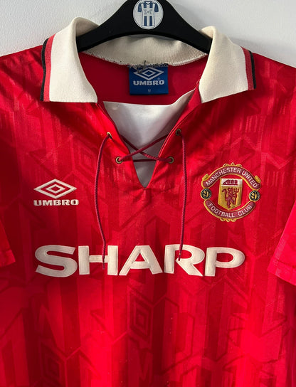 Maillot de foot vintage domicile rouge de manchester united 1992/1994. On peut retrouver l'équipementier umbro et le sponsor Sharp. Il s'agit d'un maillot authentique d'époque.