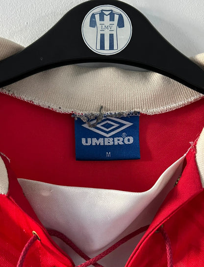 Maillot de foot vintage domicile rouge de manchester united 1992/1994. On peut retrouver l'équipementier umbro et le sponsor Sharp. Il s'agit d'un maillot authentique d'époque.